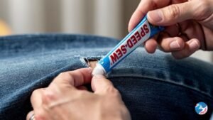 A person wearing a denim jacket with a neat DIY denim patch on the elbow.